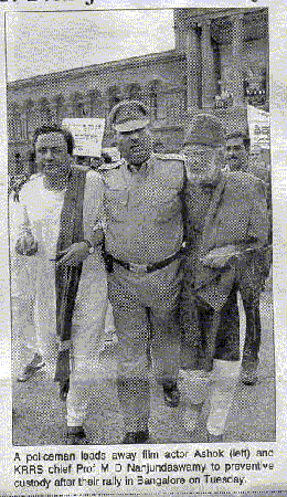 A policeman leads away film actor Ashok (left) and KRRS chief Prof. M.D. Nanjundaswamy to prevent the custody after their rally in Bangalore on Tuesday.